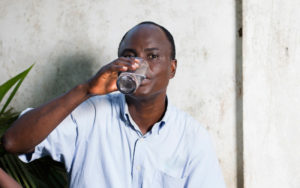 middle-aged man drinking water in a glass